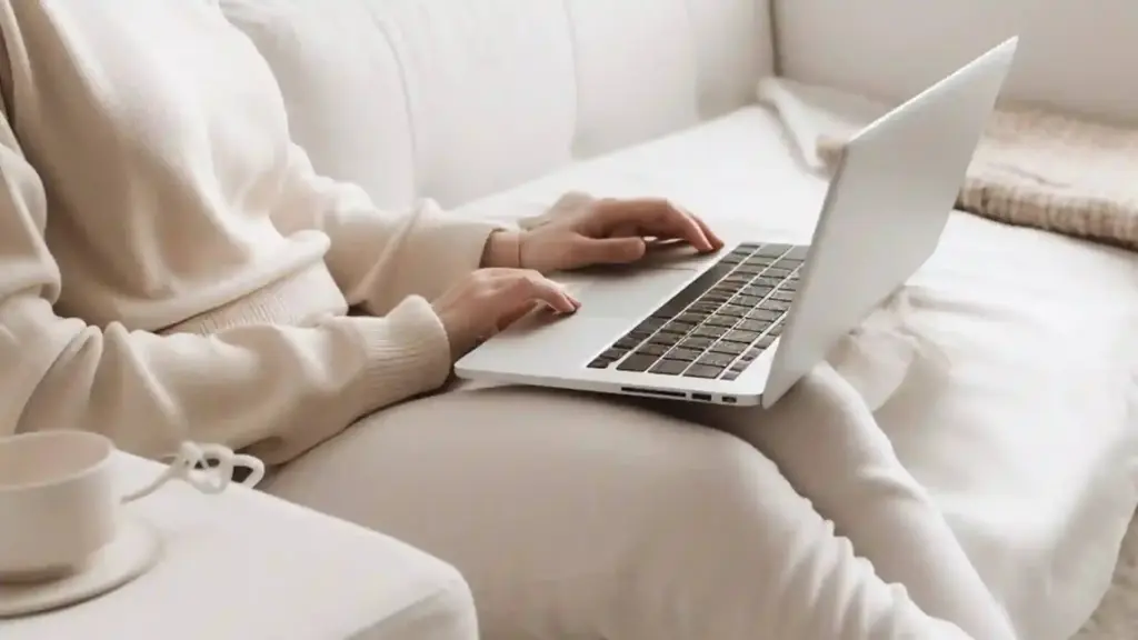 Frau mit Laptop auf Sofa